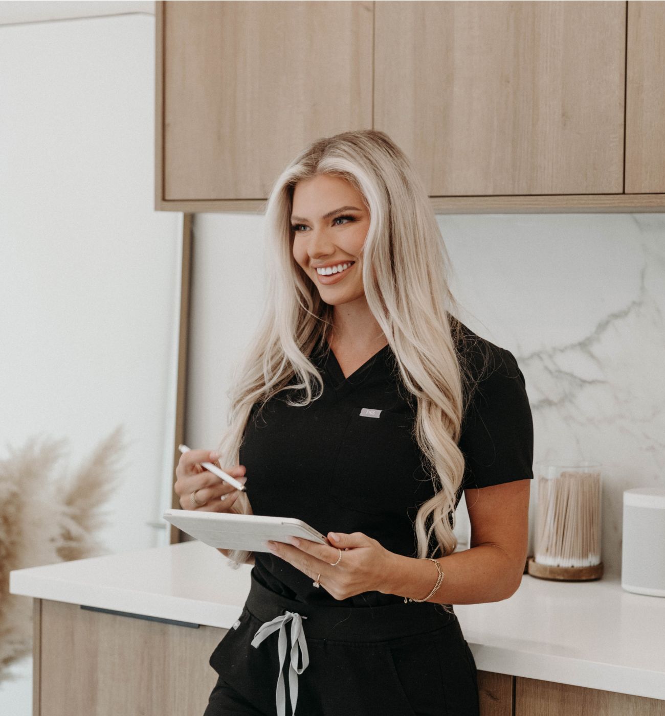 Smiling professional using a tablet in kitchen.