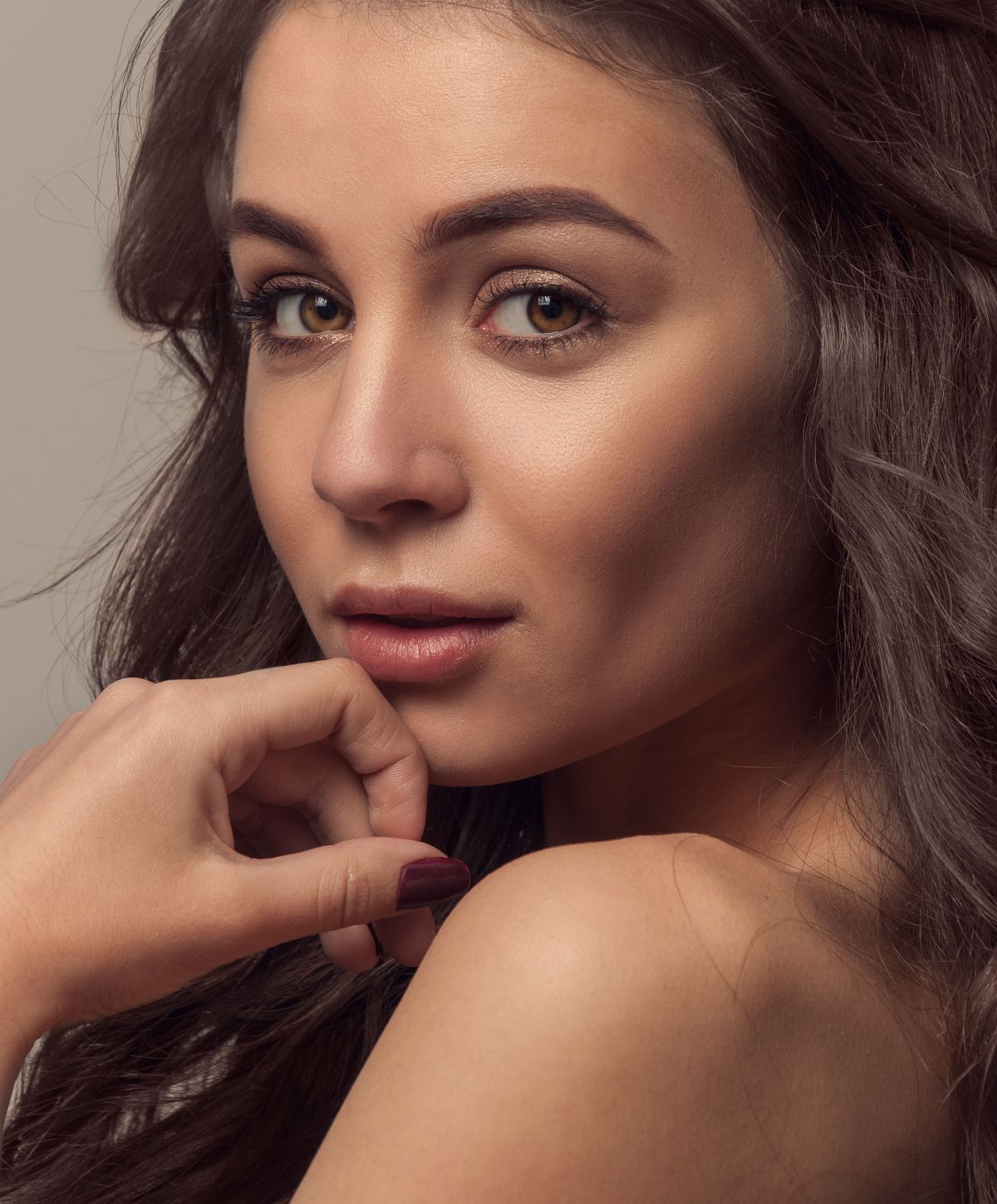 Close-up portrait of a woman with hand.